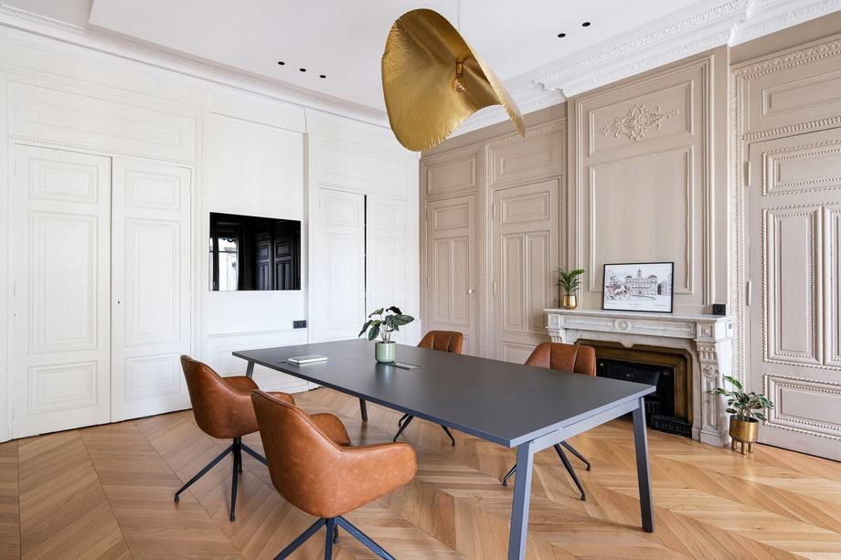 Salle de réunion aux boiseries claires et grande table de travail, au siège de Core Group à Lyon.